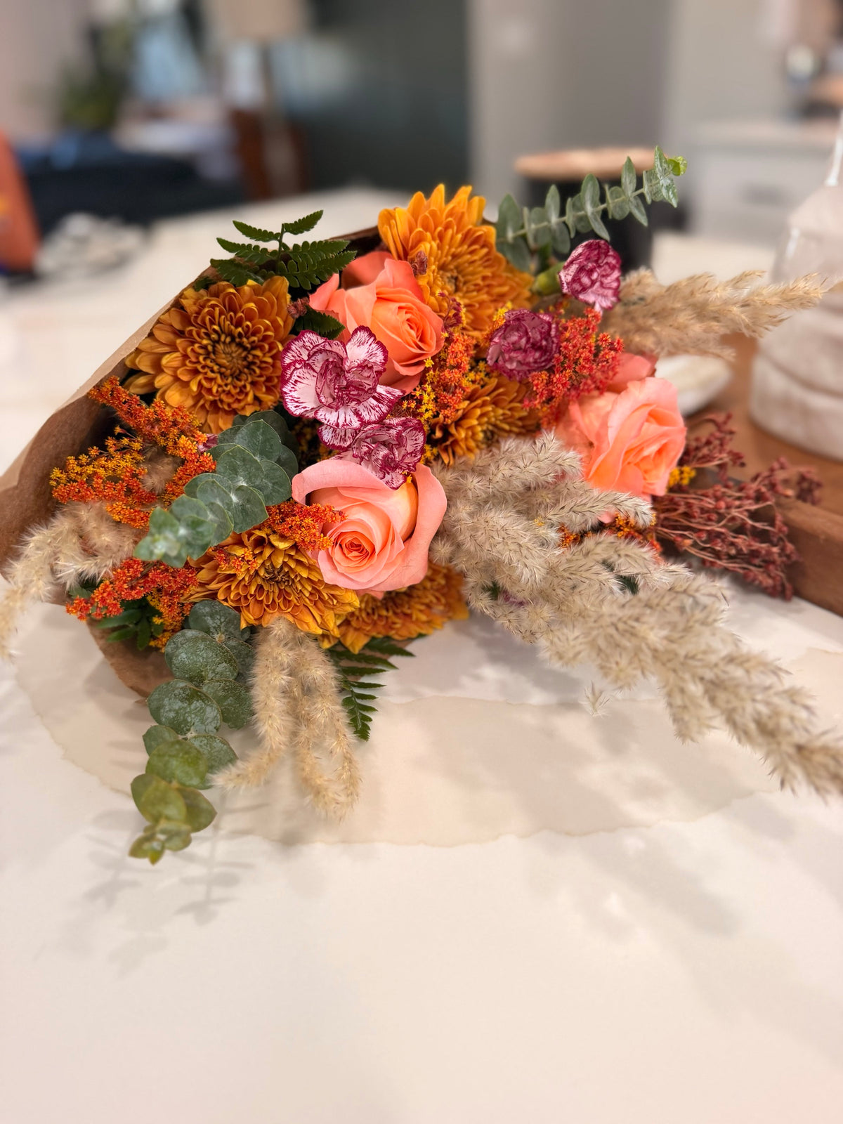 Amber Fields bouquet wrapped in kraft paper on the worktable