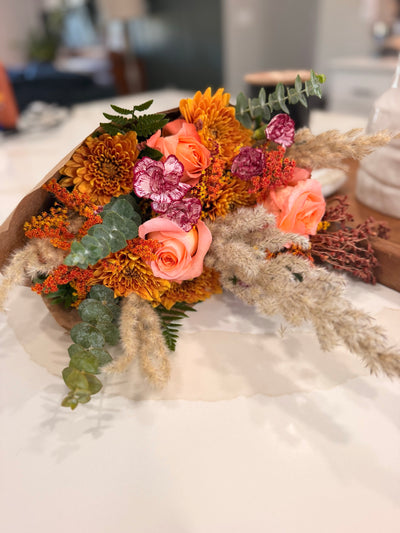 Amber Fields bouquet wrapped in kraft paper on the worktable