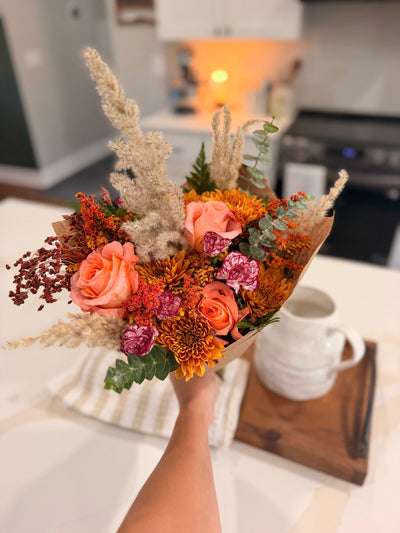 Amber Fields bouquet held above the florist worktable